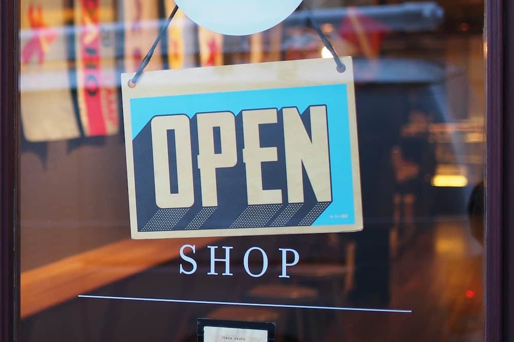 "Open" sign on store window, representing franchise loan options