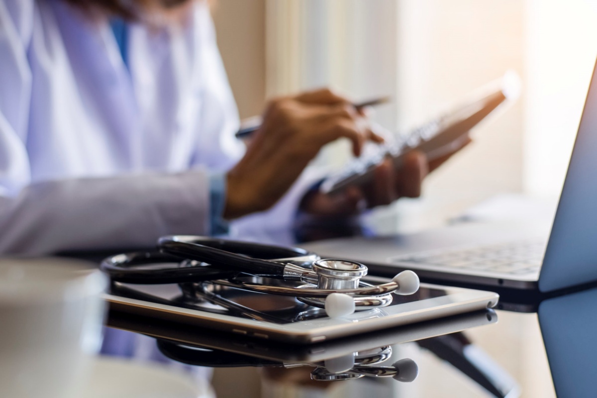 Doctor at a desk using a calculator, representing medical practice financing options.