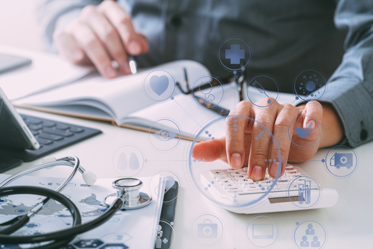 Doctor using a calculator and notebook, representing, alternative business loans for physicians and medical practices.