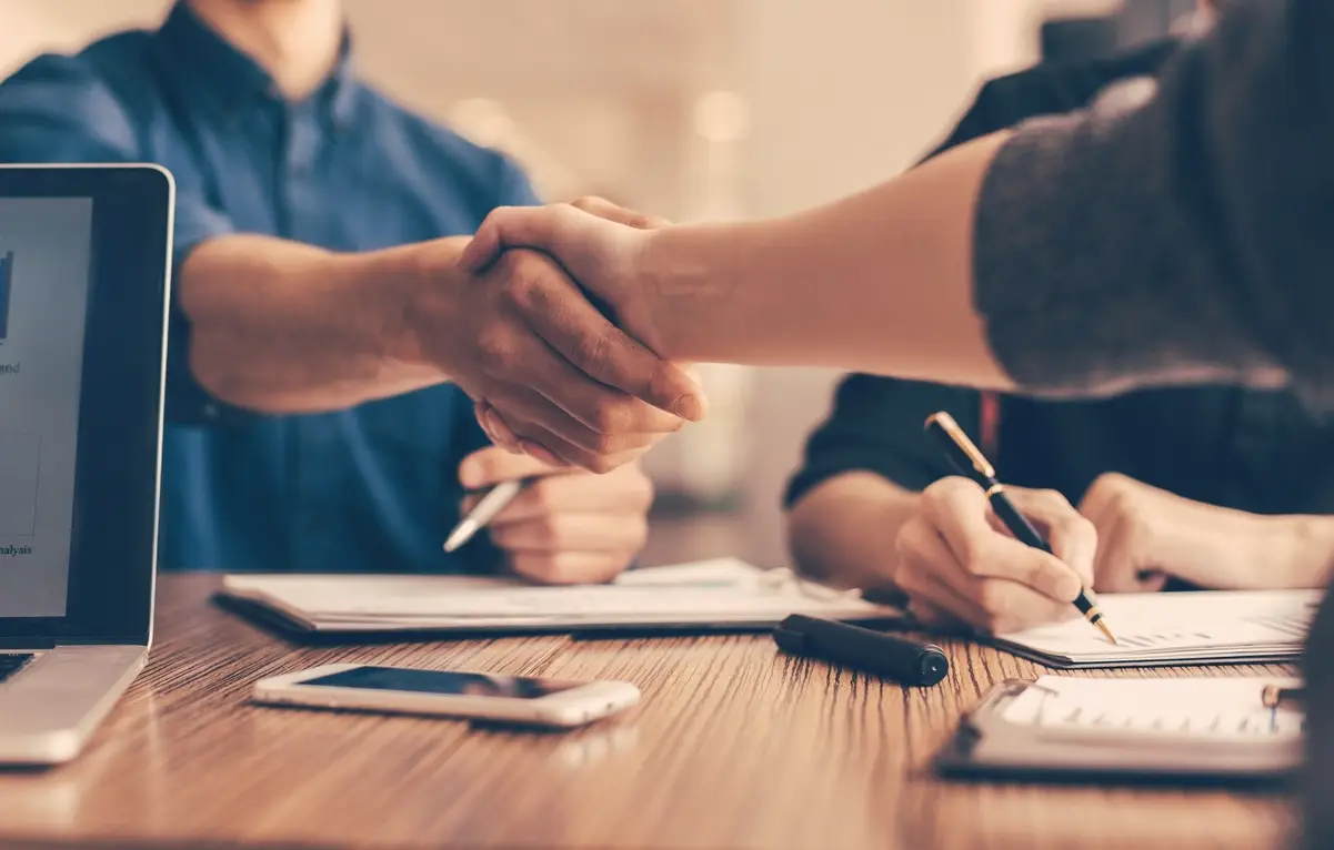 Shaking hands over a contract, representing a fast business loan approval