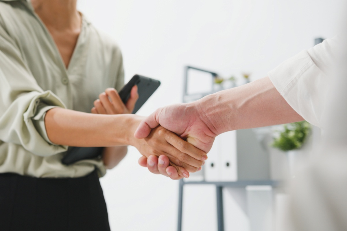 Man and women shaking hands representing Mergers and Acquisitions