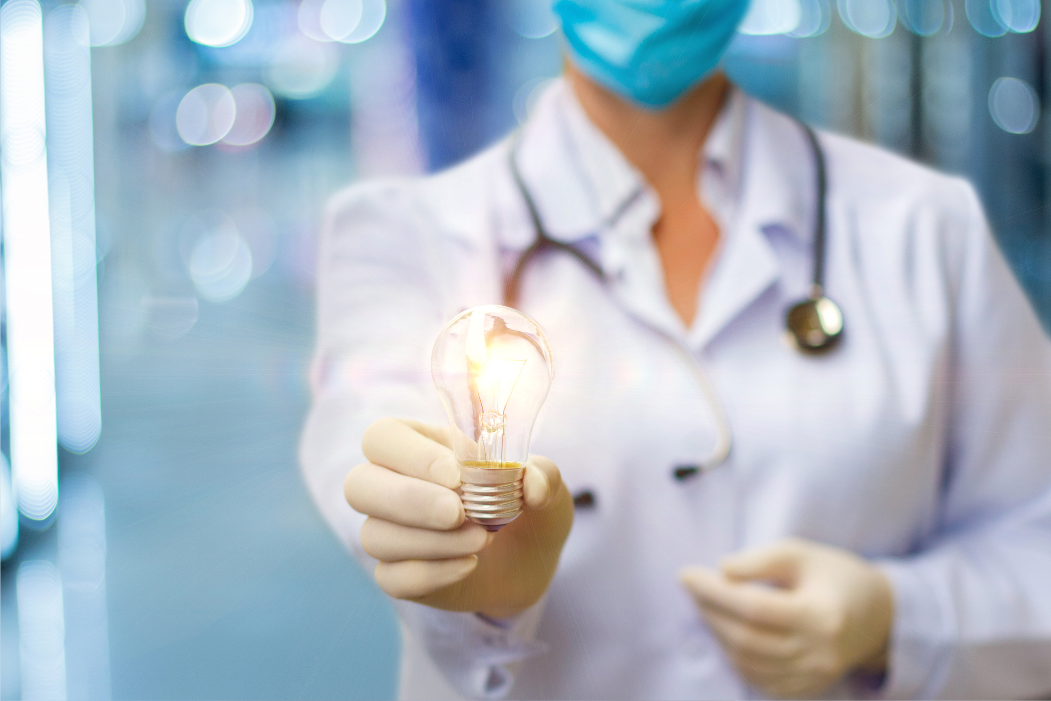 Doctor holding a lit up lightbulb, representing SBA 7a loans for physicians